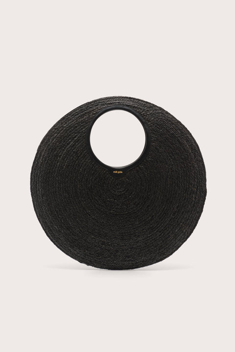 An oversized black woven circular  handbag on a light beige background