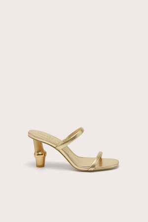 Side profile of a gold heel that features two slide straps and a gold bamboo-inspired heel.