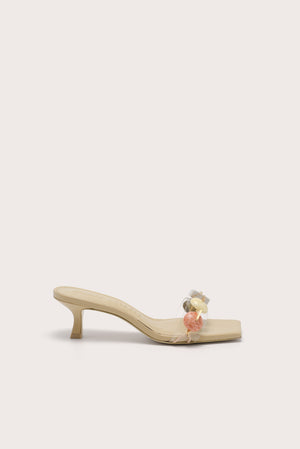 Side profile of a slip on kitten heel that features multicolored stones across the toe strap.