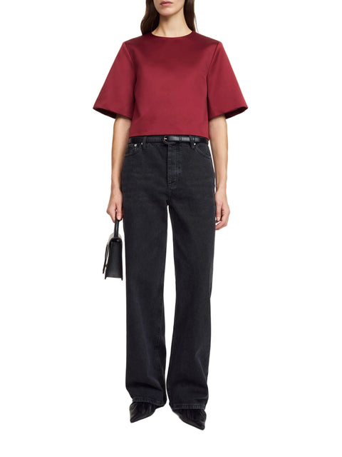 Person wearing a red top and black pants on a white background