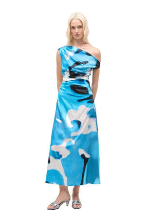 Woman wearing a blue abstract silk maxi dress on a white background