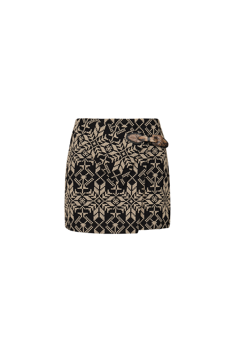 A mini skirt featuring a black and beige geometric pattern with a brown textured bow detail at the waist, shown against a plain white background.