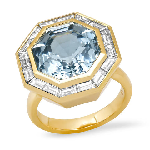 Ghost image of a gold rig that features a large octagonal aquamarine center stone set in gold and surrouned by two baguette diamonds on each of the eight sides.