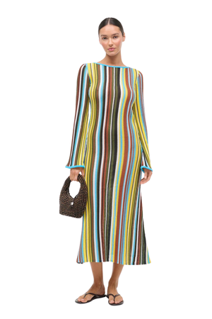 Woman wearing a multicolored striped crochet maxi dress on a white background