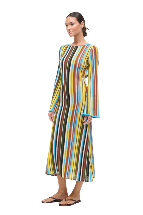 Woman wearing a multicolored striped crochet maxi dress on a white background side angle