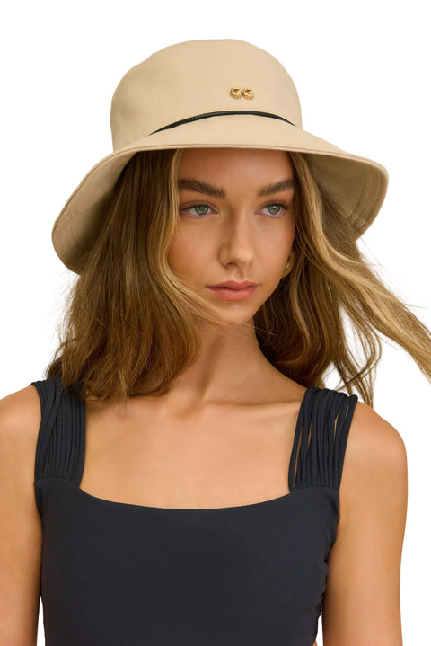 Woman wearing a beige bucket hat against a neutral background