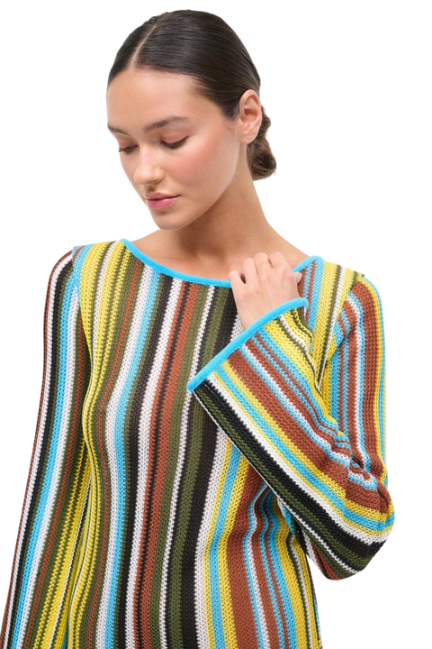 Woman wearing a multicolored striped crochet maxi dress on a white background close up