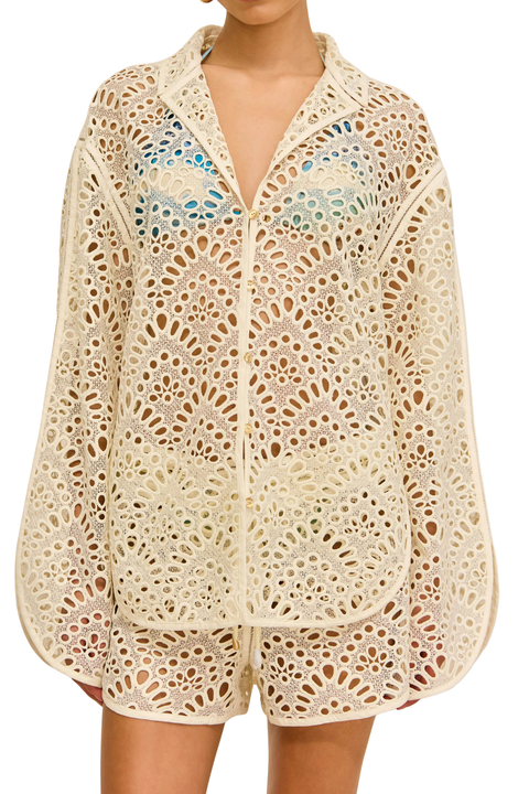 Woman wearing a beige crochet shorts cover-up under a swimsuit close up