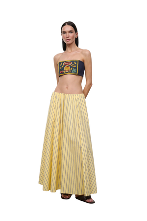 Woman wearing a yellow striped maxi skirt on a white background