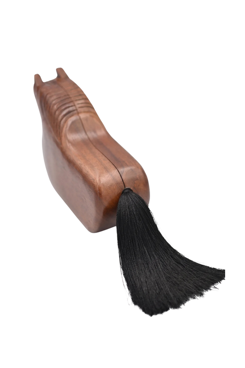 A wooden shoe tree with a black hanging tassel, shown on a plain white background.