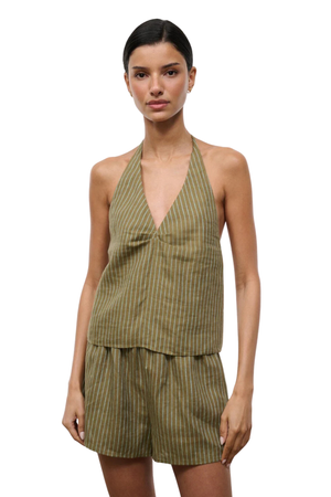 Woman wearing a green striped halter top and shorts set on a white background