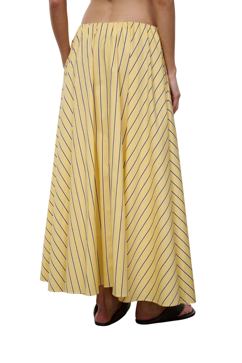 Woman wearing a yellow striped maxi skirt on a white background back angle