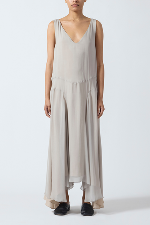 Woman wearing a grey beige sleeveless maxi dress on a white background