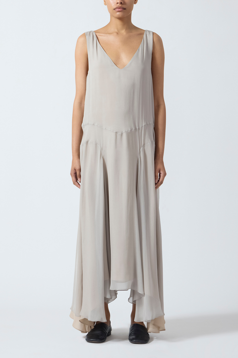 Woman wearing a grey beige sleeveless maxi dress on a white background