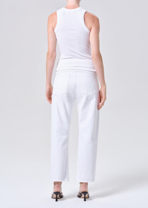 Person wearing a white sleeveless top and high-rise, straight leg, white jeans on a plain background from the back
