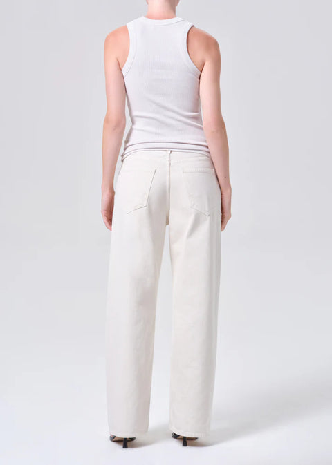 Person wearing white wide-leg, mid-rise jeans and a white top on a white background from the back