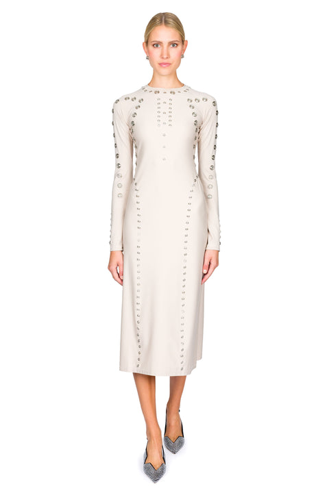 Woman posing in a long-sleeve dress beige midi dress with decorative snaps on a white background
