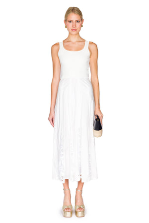 Woman wears white dress with knit bodice and cotton and lace skirt.