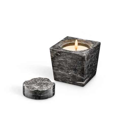 Lit marble candle with topper off to the side.