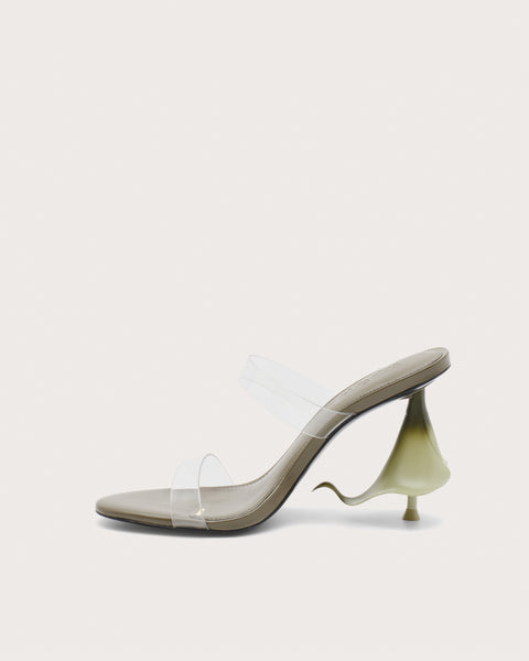 Side profile of a green high heel with clear straps and a calla lily shaped heel.