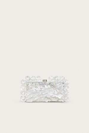 A rectangular acrylic clutch that features a silver foil design and matching open circles of silver-foiled acrylic lining the shape of the clutch.