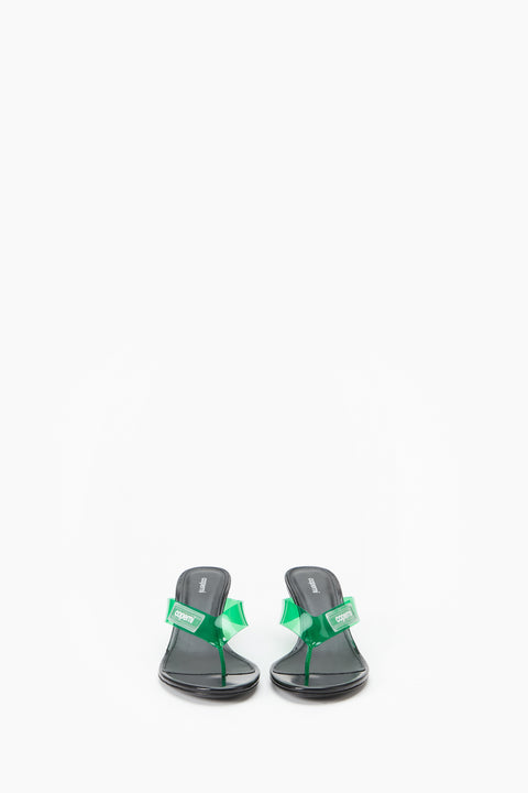 Black wedge sandal with green strap on a white background from a head on view.