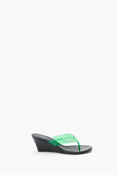 Black wedge sandal with green strap on a white background from the side view.