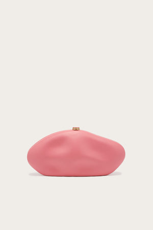 An abstract, oblong clutch covered in smooth pink leather that features indents for a sculptural look, complete with gold-toned hardware.
