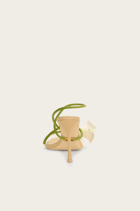 High-heeled shoe with lily and green strap on a white background from the back.