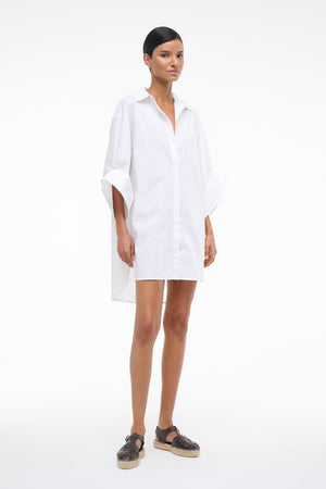 Woman wearing a white shirt dress on a white background