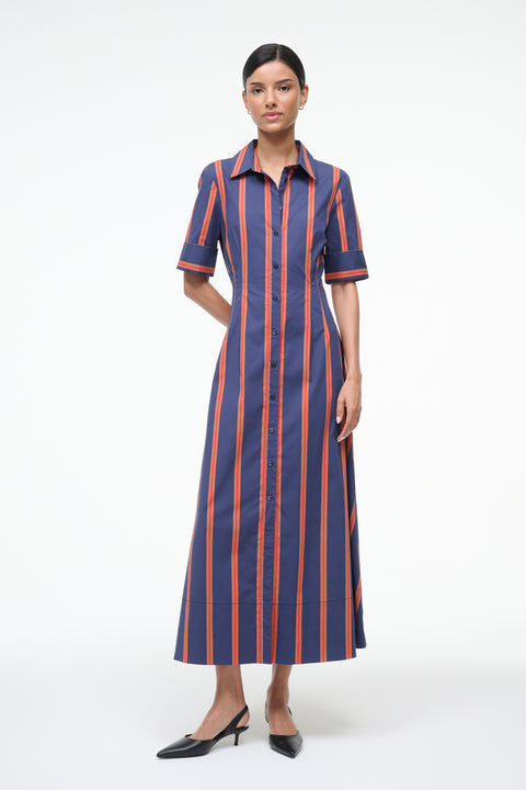 Woman wearing a blue and orange striped maxi dress on a white background