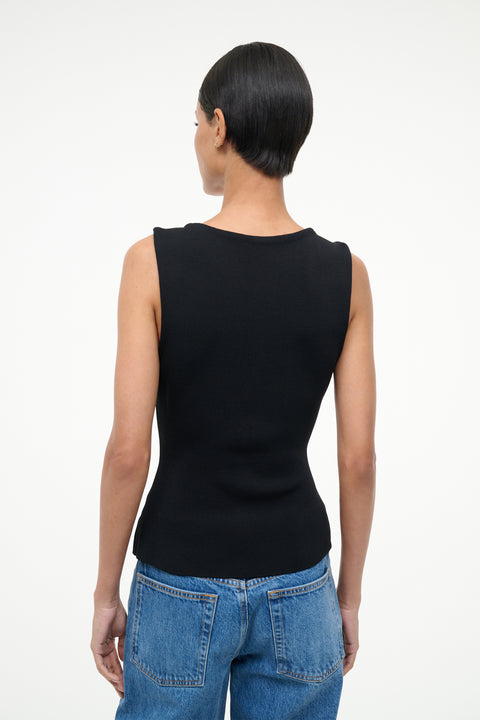 Back-facing person wearing a black sleeveless top and blue jeans on a white background