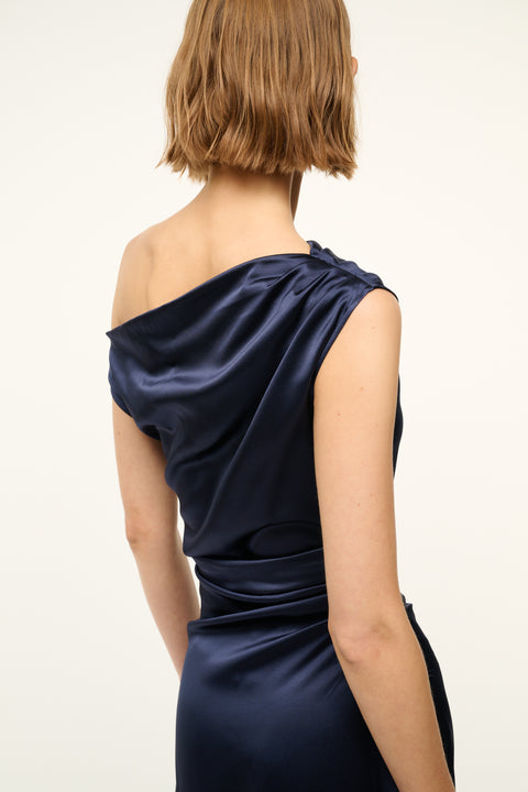 Navy blue one-shoulder dress worn by a person on a white background