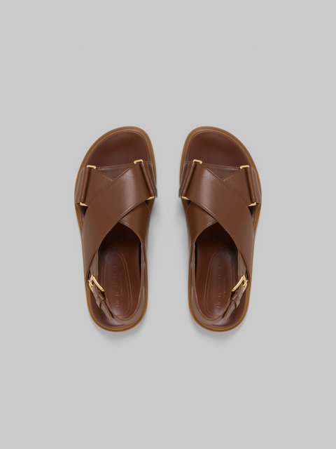 Top view of a pair of crisscross brown leather sandals with heel strap.