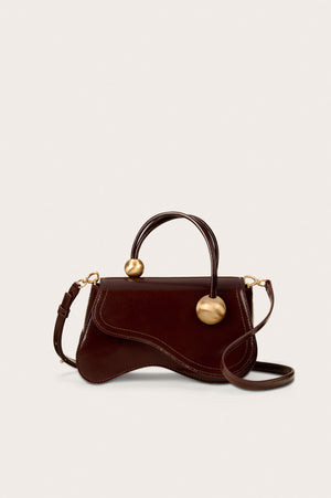 Brown leather handbag with rope handle and front flap.