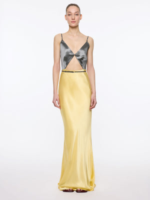 Woman wearing a two-tone dress with a metallic gunmetal top and yellow skirt on a white background