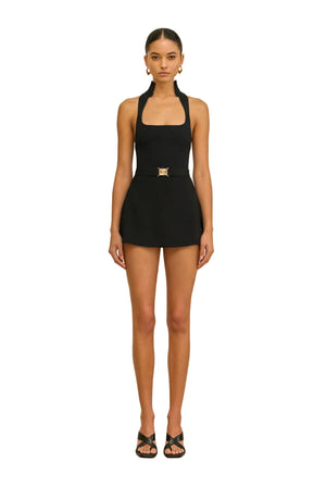 Woman wearing a black halter top with square neckline on a white background