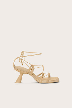 Side-facing raffia heel that features a gladiator-style lace up design with a unique comma heel.