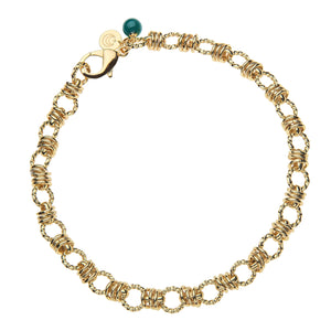 A gold chain necklace made of knotted links and rings with a malachite bead attached the the lobster claw clasp.
