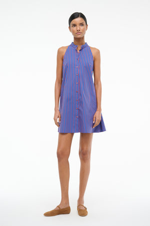 Front-facing woman wearing a red and blue stripe poplin mini dress that features a stand collar and front button closure, paired with brown flats.