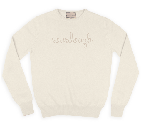 Cream crewneck sweater with "sourdough" hand stitched on the chest in sand colored thread.