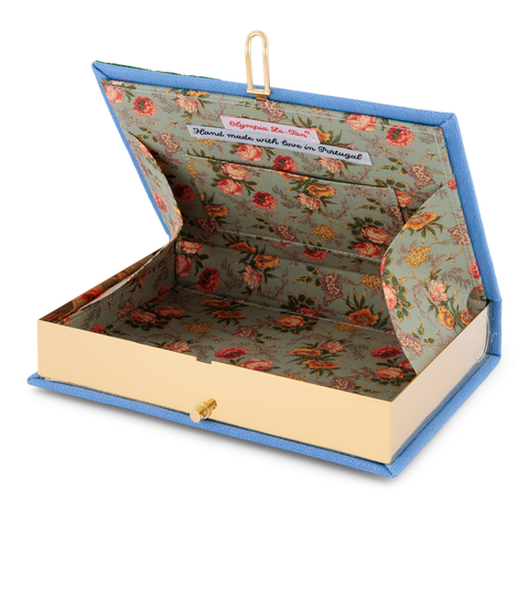 Inside look at book clutch with floral-pattern and small interior pocket on a white background