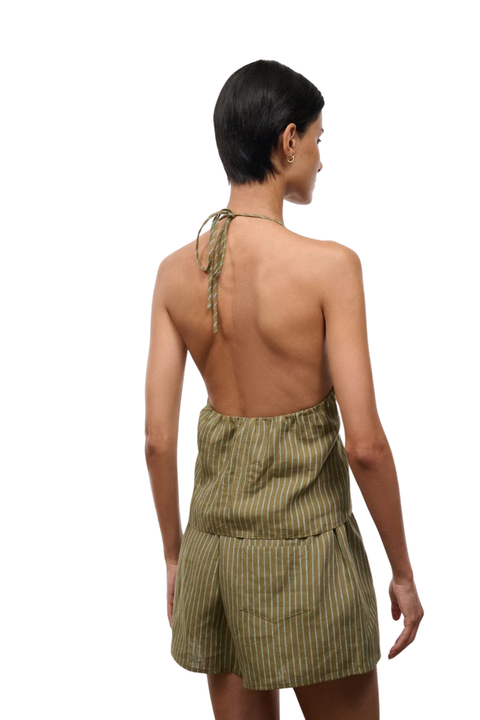 Woman wearing a green striped halter top and shorts set on a white background back angle