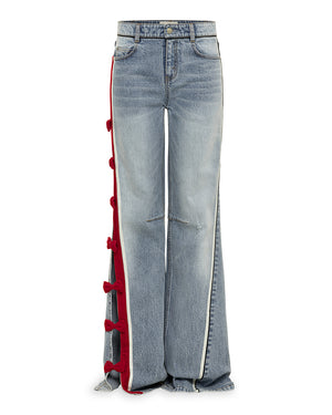 Blue jeans with red side panels with red velvet bows on a white background