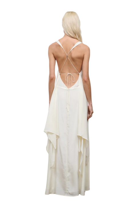 Woman wearing a long white silk dress with an open back