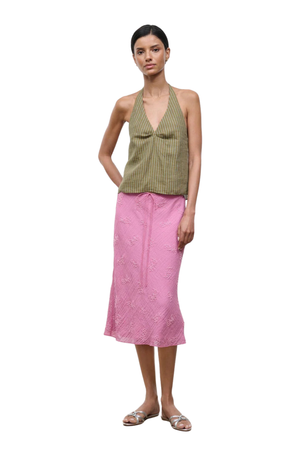 A woman wearing a pink midi skirt with beaded embellishments and a drawstring waist