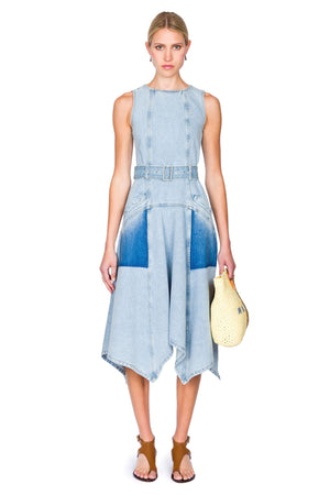 Woman wearing a blue denim dress holding a yellow handbag on a white background