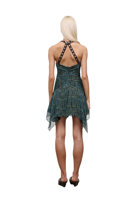 Woman wearing a patterned blue and brown dress with studs on a white background back angle