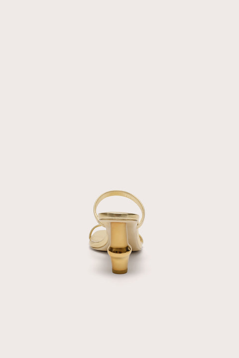 Back view of a gold heel that features two slide straps and a gold bamboo-inspired heel. 