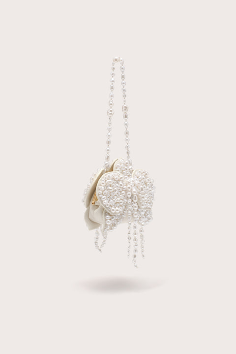 A side-facing white, pearl-beaded wristlet crafted to resemble a blooming flower, with a white leather pouch. 